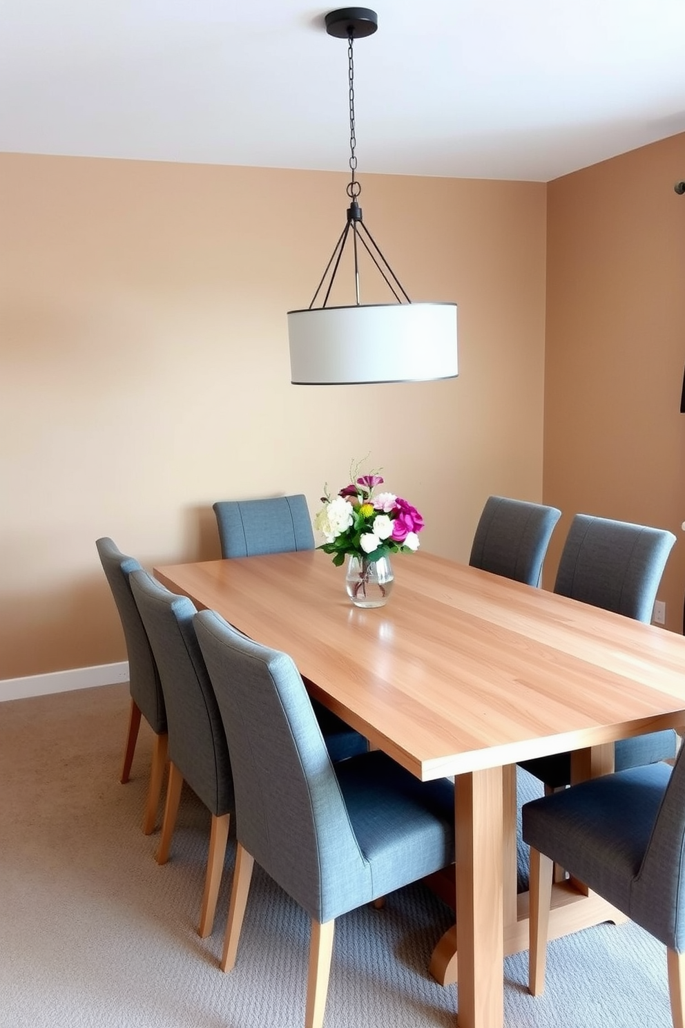 An expandable dining table is elegantly set in a cozy dining area. The table is made of light wood and features sleek lines, surrounded by modern upholstered chairs in a soft gray fabric. The walls are painted in a warm beige tone, creating a welcoming atmosphere. A stylish pendant light hangs above the table, casting a soft glow over a centerpiece of fresh flowers.