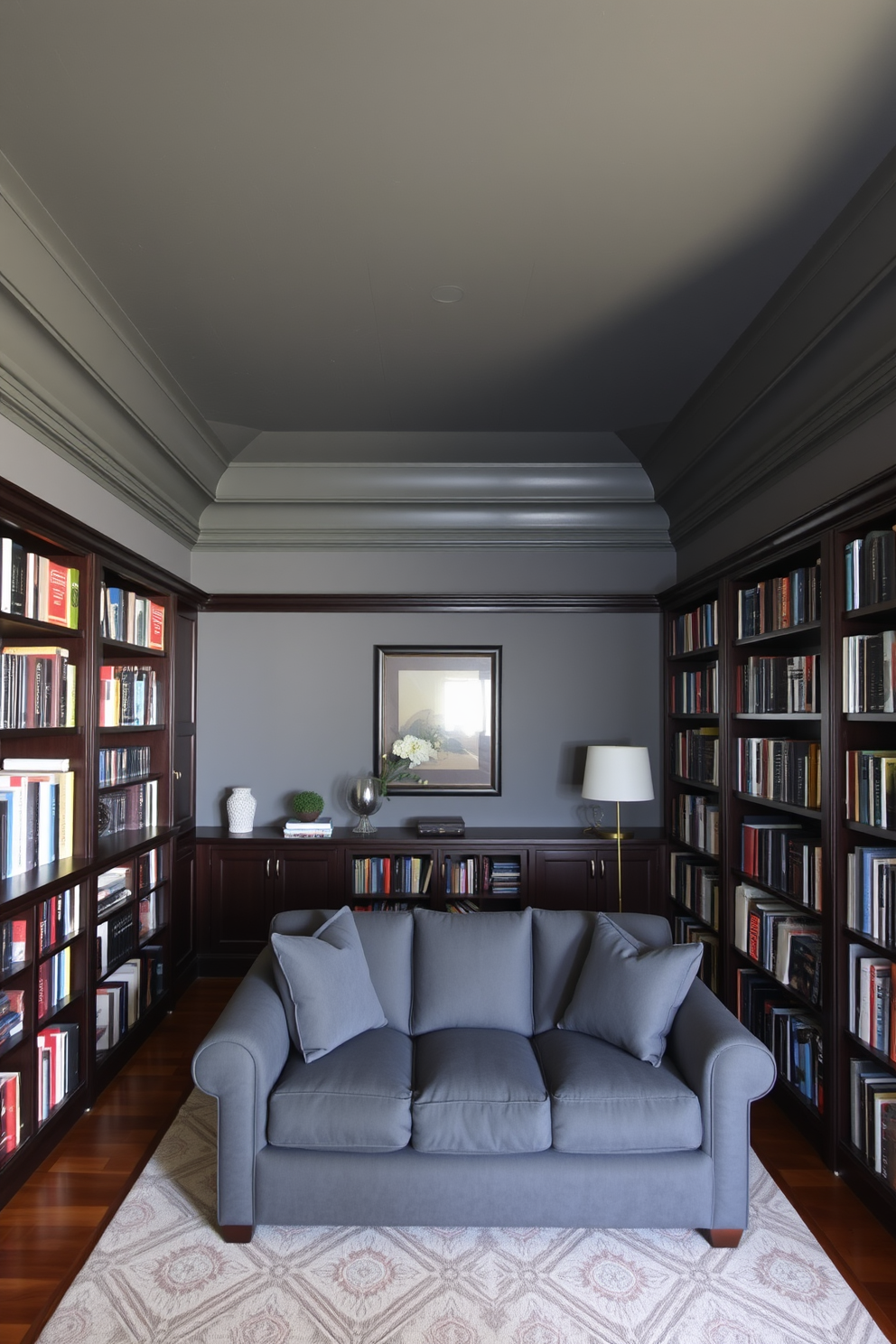 A cozy home library with gray-painted ceilings that create a unique ambiance. The walls are lined with dark wood bookshelves filled with an array of books, and a plush gray sofa invites relaxation.
