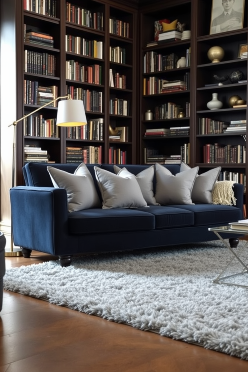 Chic gray throw pillows are artfully arranged on a deep navy sofa, adding a touch of elegance and comfort to the space. The walls are lined with dark wood bookshelves filled with an eclectic mix of books and decorative items, creating a cozy yet sophisticated atmosphere. The library features a plush gray area rug that complements the throw pillows and anchors the seating area. A stylish floor lamp stands in the corner, providing warm light for reading while enhancing the overall design aesthetic.