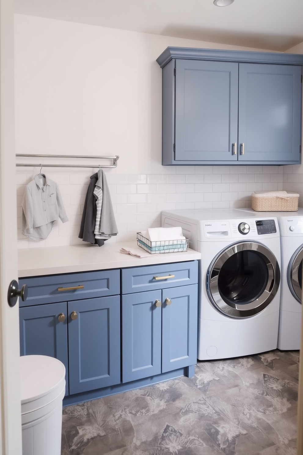 A stylish laundry room featuring a spacious countertop dedicated to folding clothes. The cabinetry is a soft blue, complemented by white subway tiles on the walls and a durable gray floor.