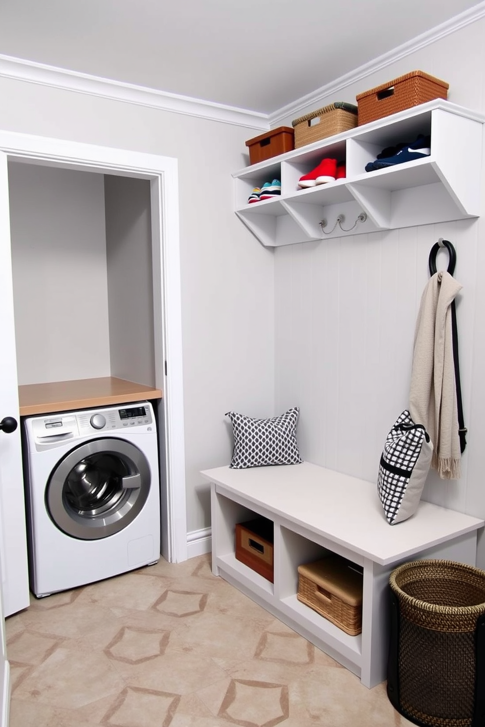 A functional mudroom laundry combo space features a built-in bench with storage cubbies above for shoes and bags. To the left, a stackable washer and dryer are neatly integrated into cabinetry with a countertop for folding clothes. The walls are painted in a light gray hue, providing a fresh and airy feel. A durable tile floor with a geometric pattern adds visual interest while being easy to clean.