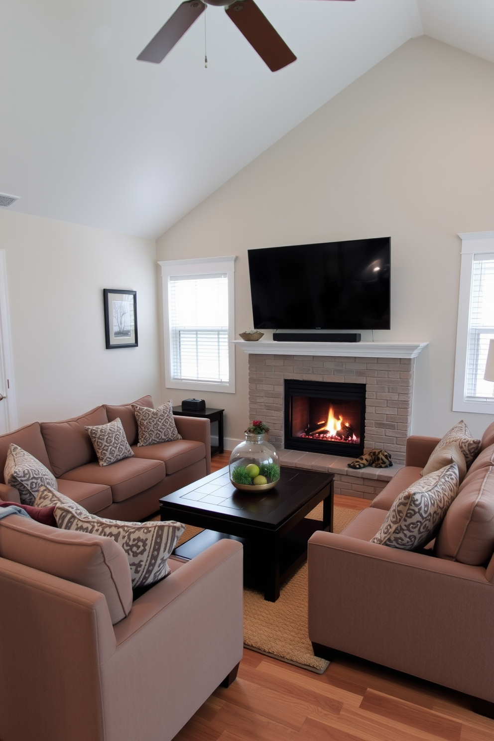 A cozy living room features a plush sectional sofa arranged around a warm and inviting fireplace. The space is enhanced with a large flat-screen TV mounted above the mantel, creating an ideal spot for relaxation and entertainment.