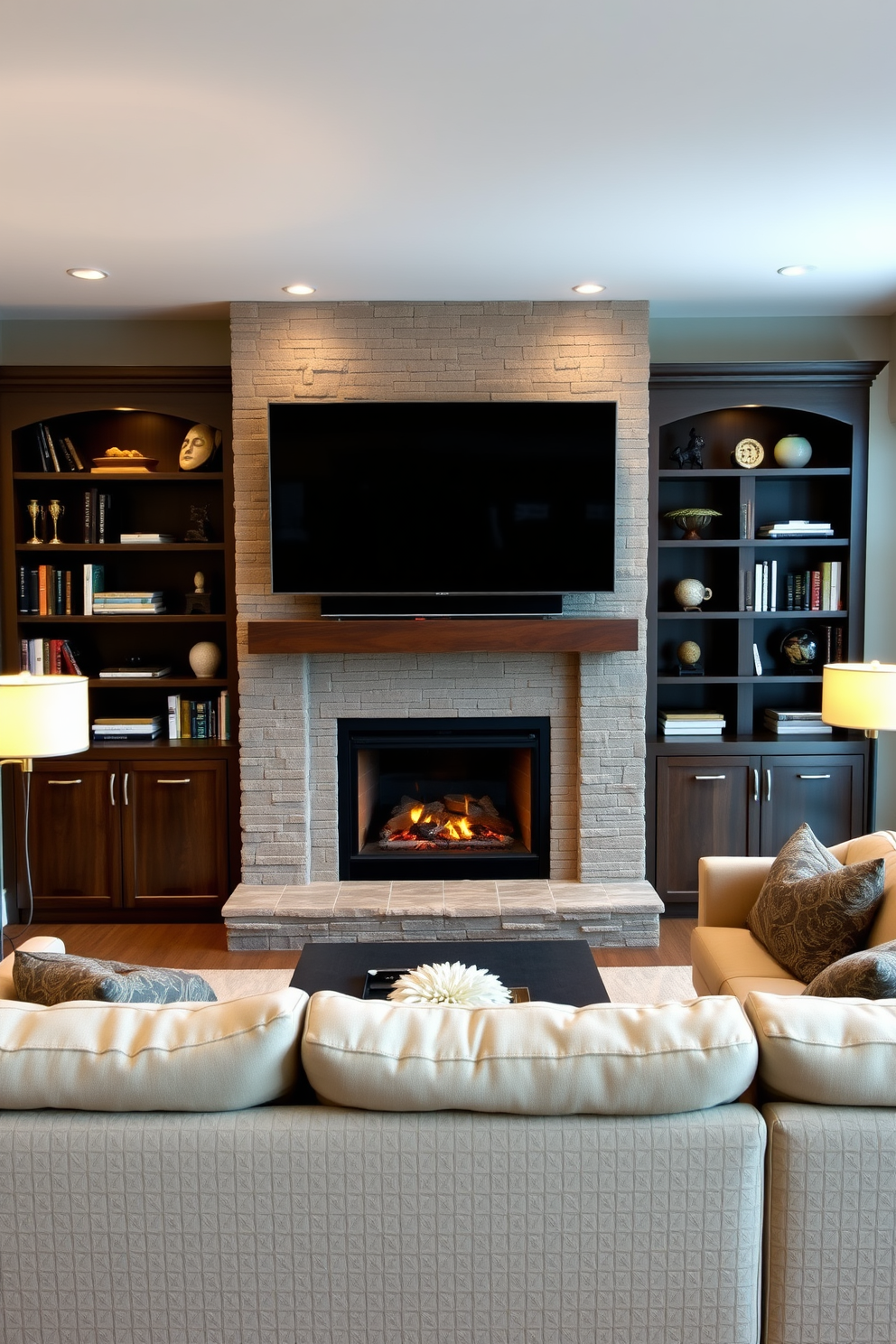 A cozy living room features a modern stone surround fireplace that serves as the focal point of the space. Flanking the fireplace are built-in shelves adorned with books and decorative items, while a plush sectional sofa invites relaxation. The room is designed with a large flat-screen TV mounted above the fireplace, seamlessly integrating entertainment into the aesthetic. Warm lighting from stylish floor lamps enhances the inviting atmosphere, creating a perfect setting for gatherings.