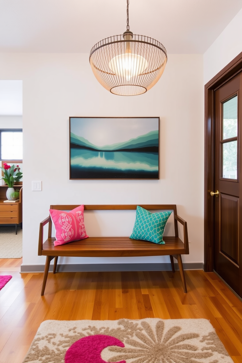A sleek wooden bench is positioned against the wall in the foyer, adorned with vibrant cushions that add a pop of color. The space is illuminated by a statement pendant light, creating an inviting atmosphere with a blend of Mid Century Modern elements and contemporary flair.