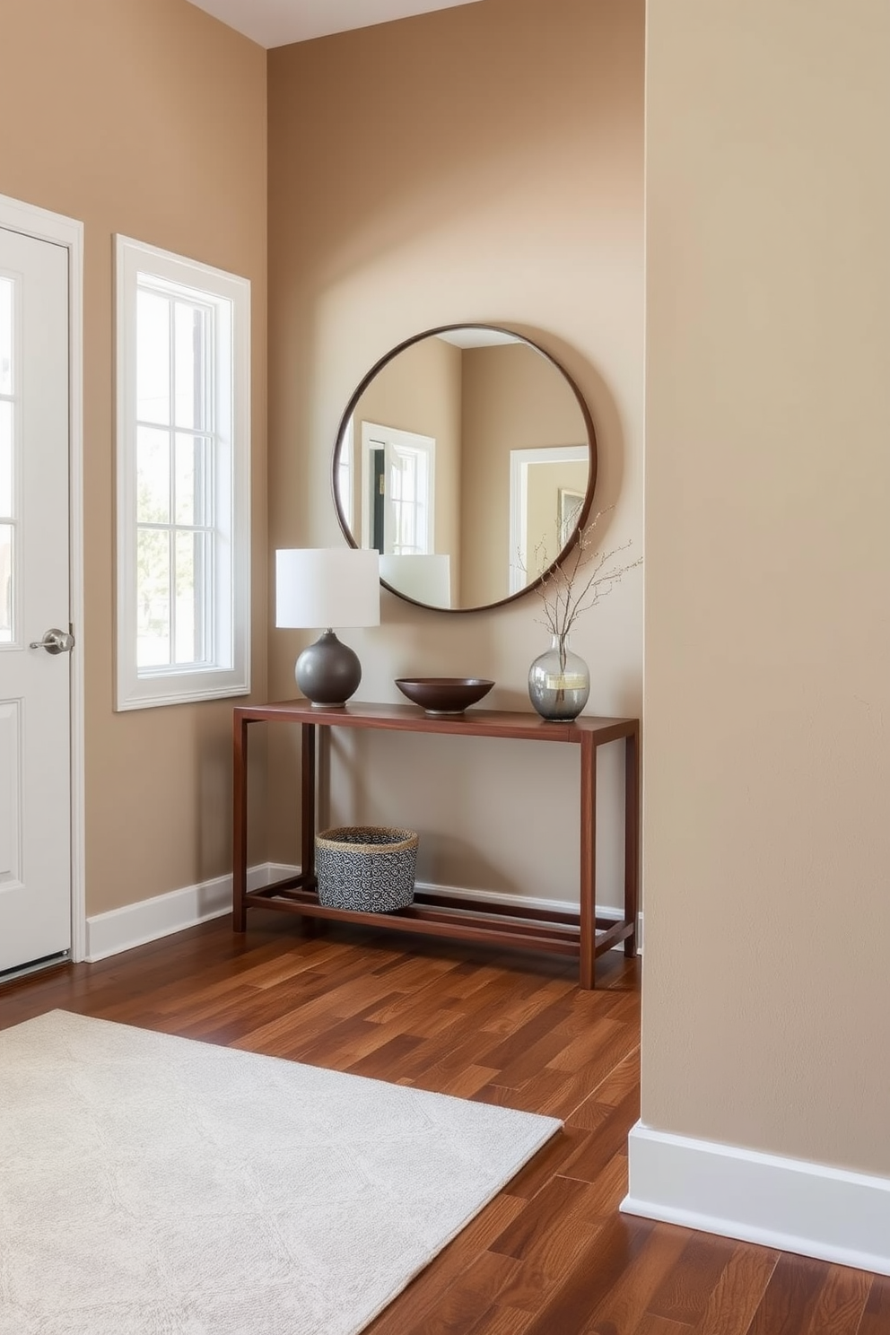 A welcoming foyer featuring a cohesive color palette that harmonizes warm earth tones with soft neutrals. The space includes a sleek console table made of walnut, adorned with a minimalist lamp and a decorative bowl. The walls are painted in a soft taupe, complemented by a geometric area rug that adds texture. A large round mirror hangs above the console, reflecting natural light from a nearby window, enhancing the airy feel of the room.