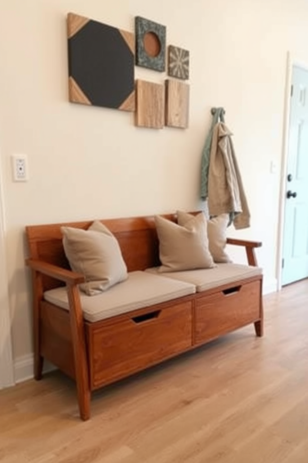 A functional bench with hidden storage is placed against the wall in the foyer. The bench features clean lines and a warm wood finish, complemented by soft cushions in a muted color palette. Above the bench, a series of geometric wall art pieces add visual interest. The flooring is a light hardwood, enhancing the spacious feel of the Mid Century Modern design.