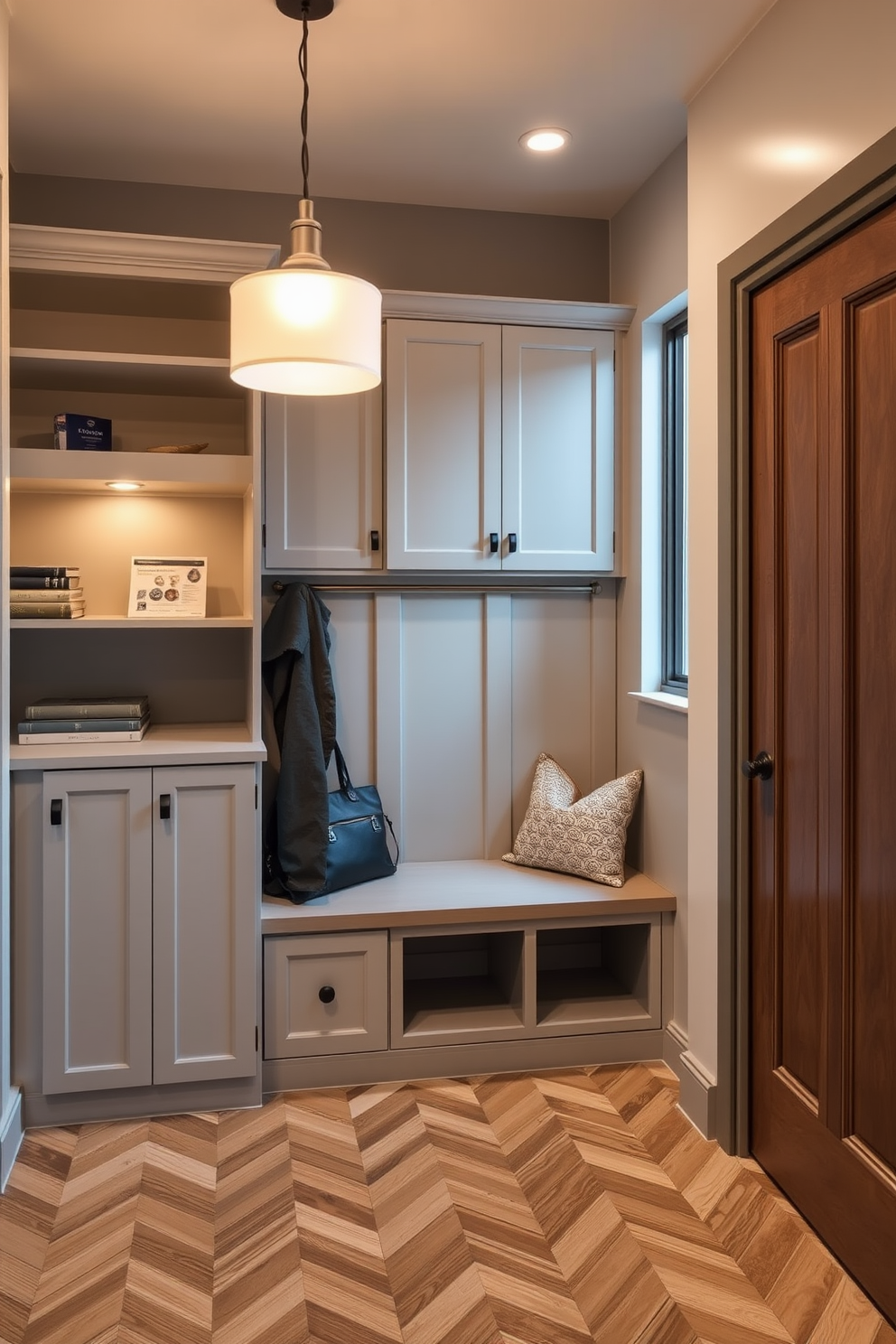 A sleek mudroom featuring a combination of open shelving and closed cabinetry. The space is illuminated by modern pendant lighting that creates a warm and inviting ambiance. The walls are painted in a soft gray tone, complemented by a stylish bench for seating. Durable flooring in a herringbone pattern adds a touch of elegance while ensuring practicality.