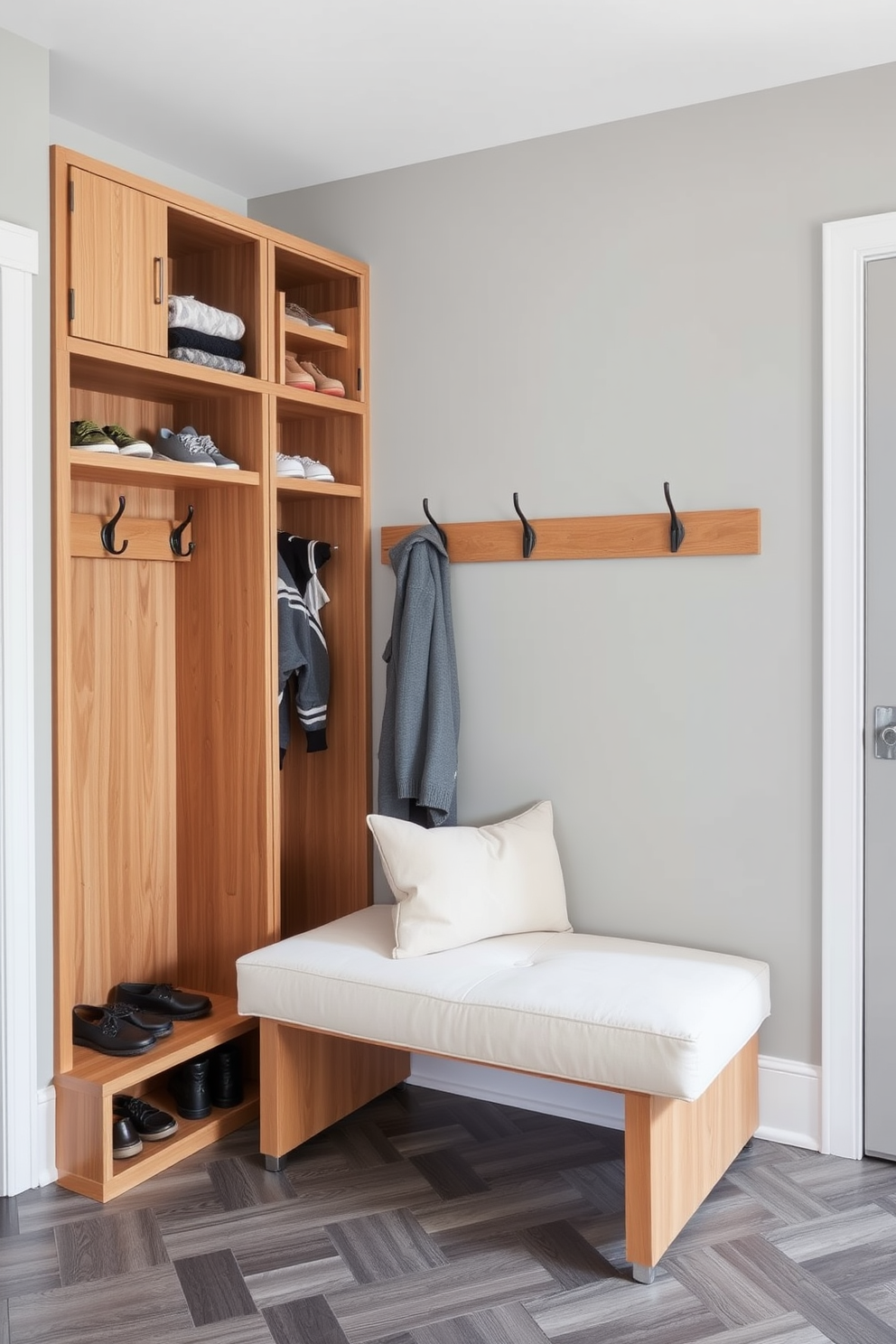 Stylish mudroom lockers for family use. The lockers are crafted from natural wood with a sleek finish, featuring hooks for coats and cubbies for shoes. The walls are painted in a soft gray, complemented by a durable tile floor in a herringbone pattern. A bench with plush cushions sits below the lockers, perfect for putting on and taking off shoes.