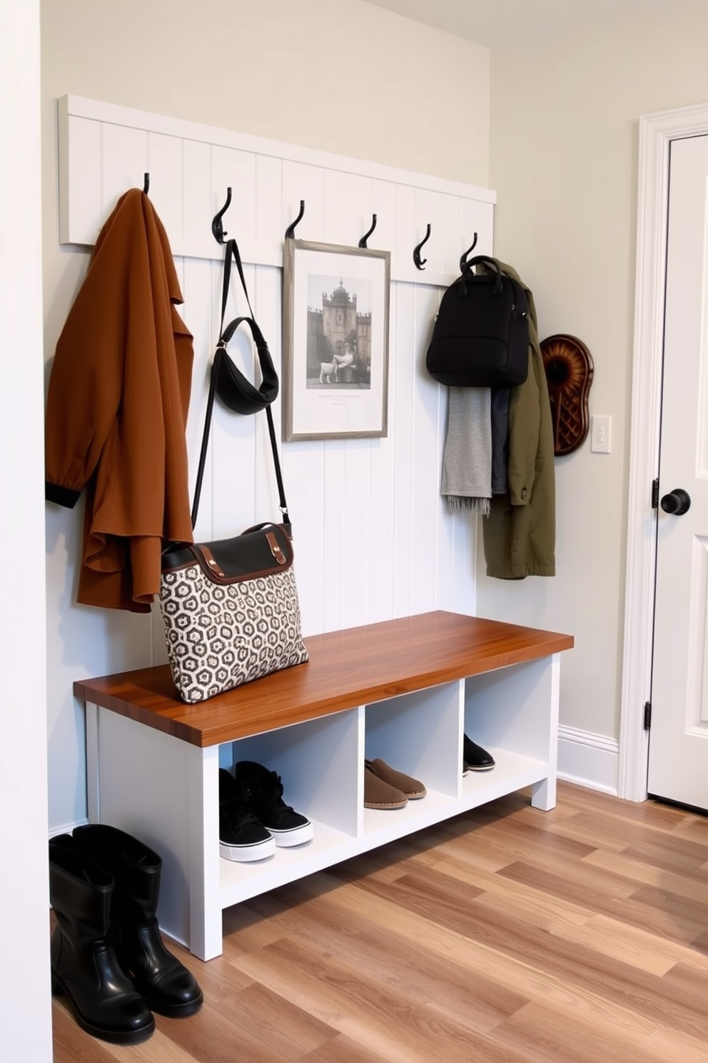 A modern mudroom features a stylish wooden bench with hidden shoe storage underneath. The bench is paired with hooks for coats and bags, and the walls are adorned with a light, neutral paint to enhance the space.
