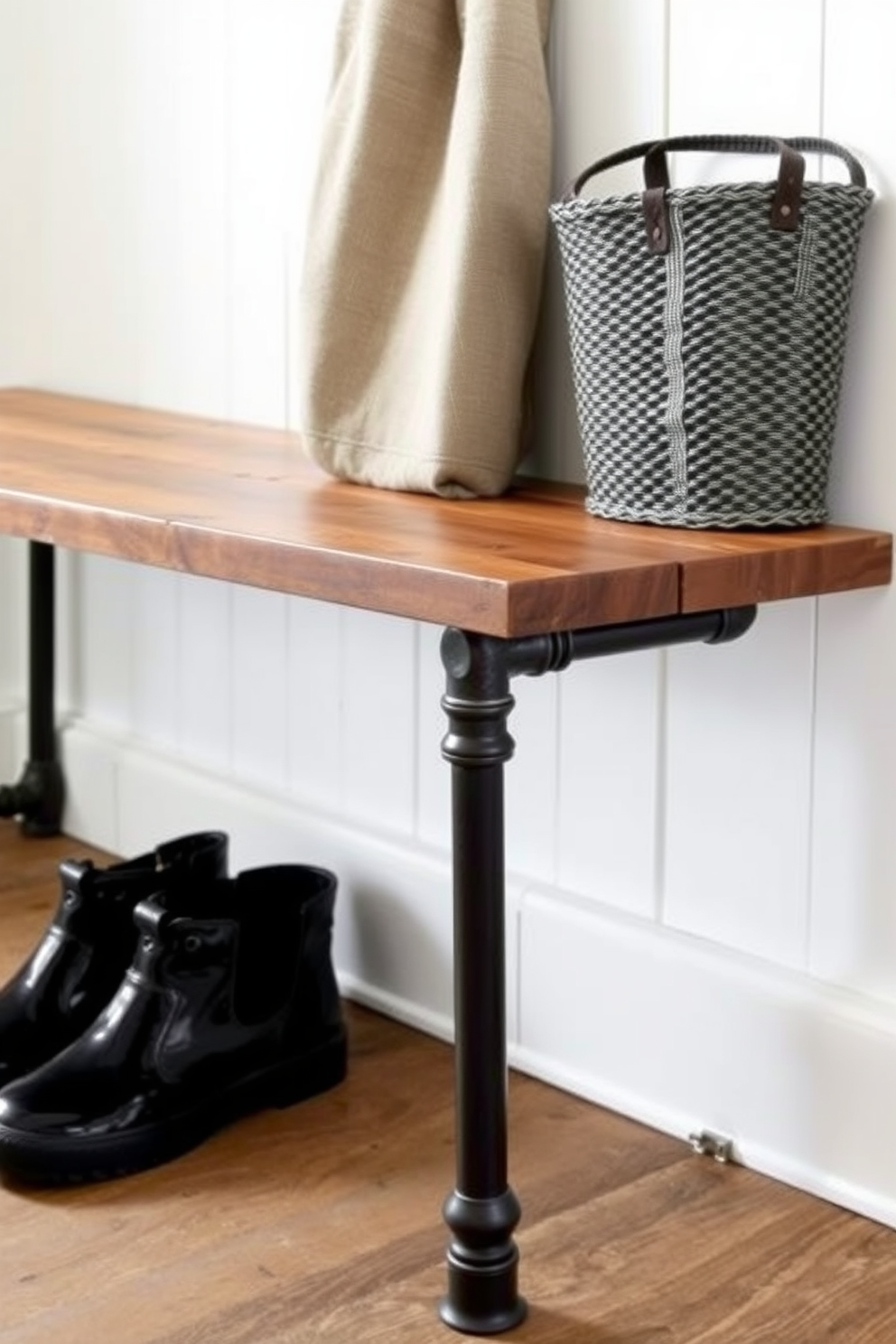 An industrial style bench features sturdy pipe legs that provide a strong and rugged aesthetic. The bench is topped with a reclaimed wood surface that adds warmth and character to the mudroom space.