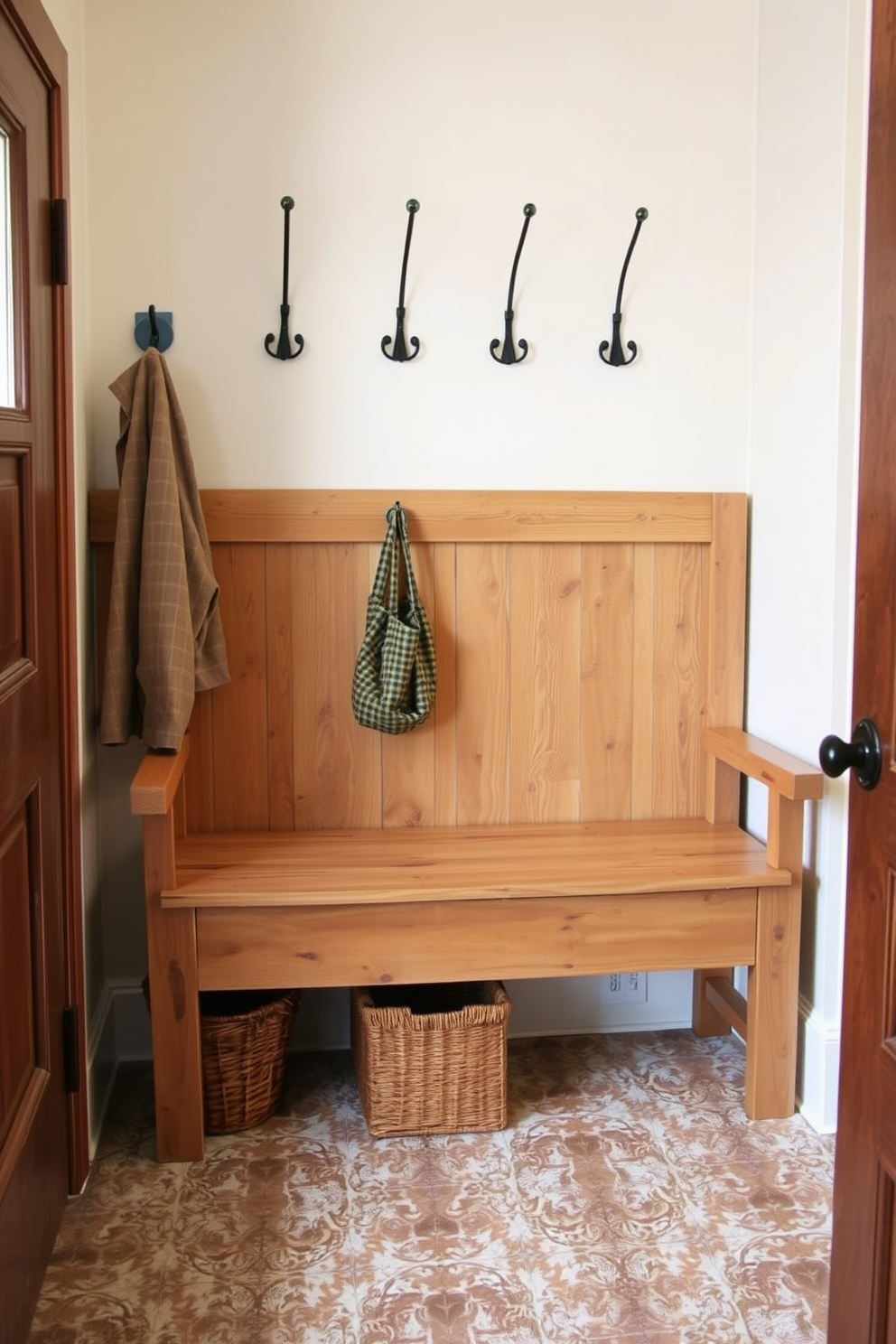 A rustic wood bench is positioned against the wall in the mudroom, featuring a natural finish that highlights the grain and texture of the wood. Above the bench, several coat hooks are mounted, providing a convenient space for hanging jackets and bags. The floor is adorned with patterned tiles that complement the rustic aesthetic, while a woven basket sits underneath the bench for additional storage. Soft lighting illuminates the area, creating a warm and inviting atmosphere perfect for welcoming guests.