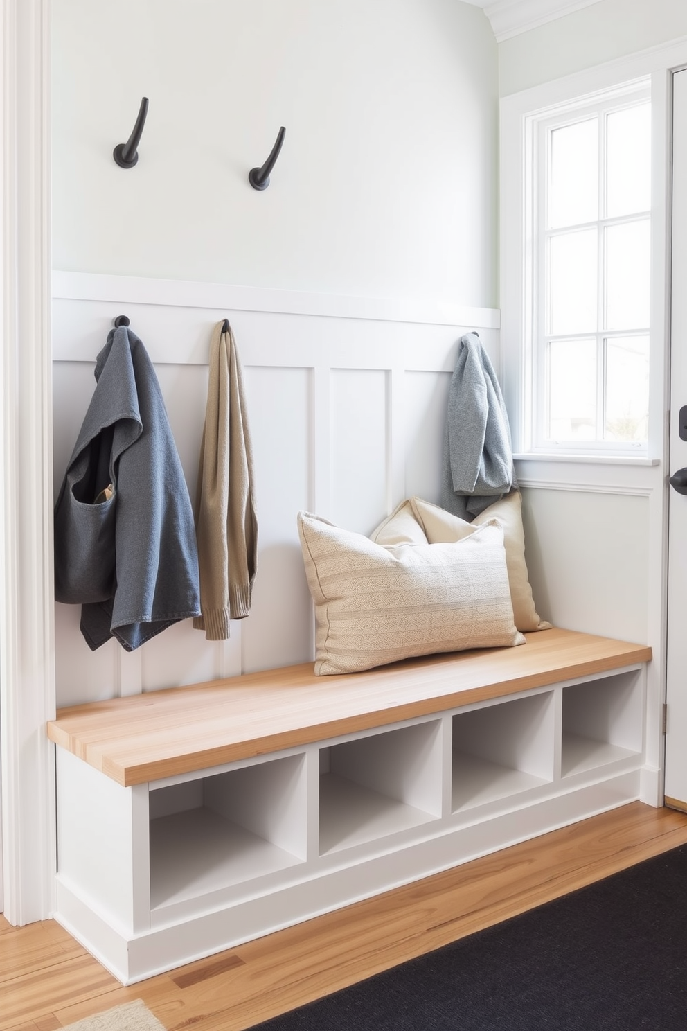 A minimalist bench with sleek lines is positioned against the wall in a spacious mudroom. The bench features a light wood finish and is paired with soft, neutral cushions for added comfort.