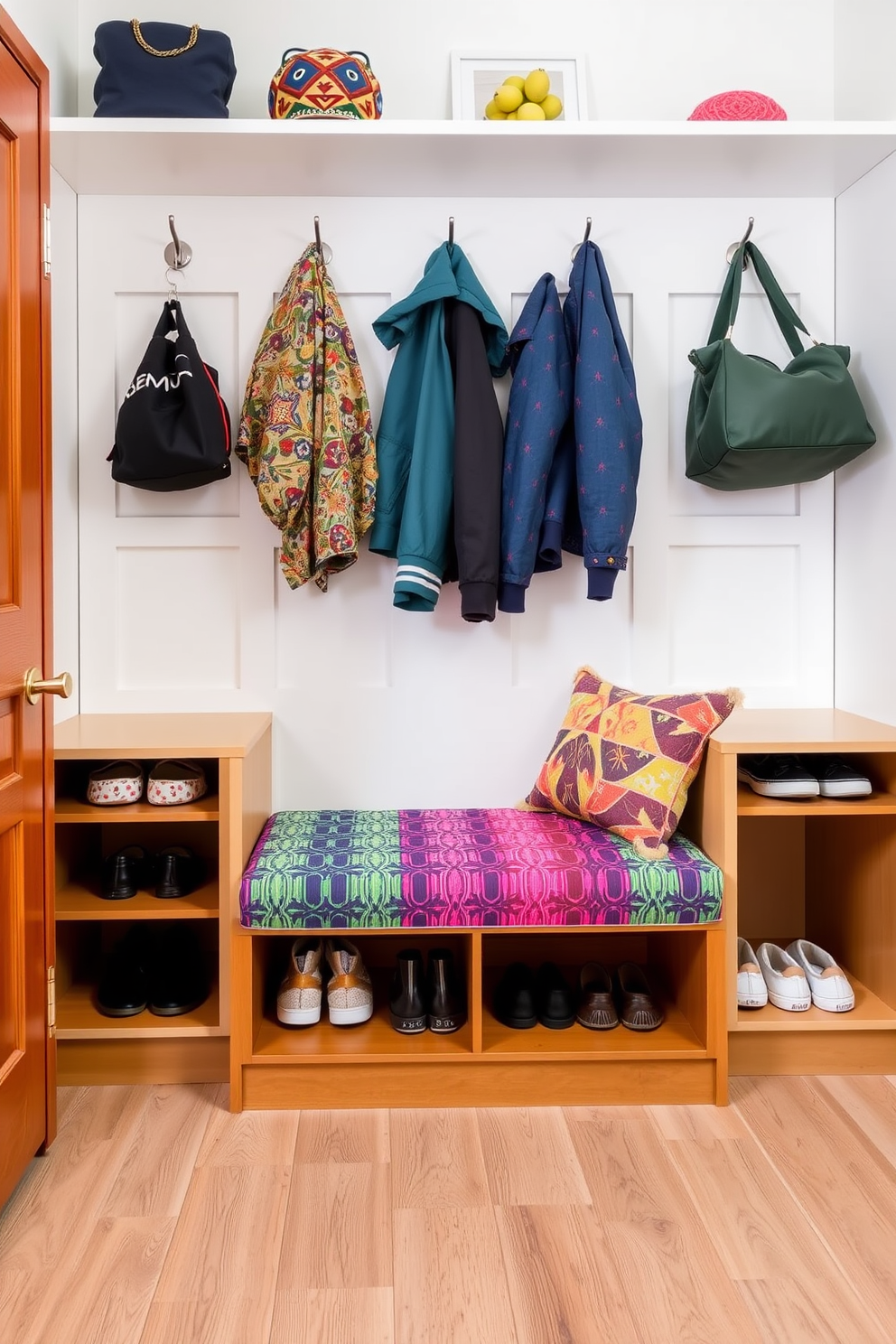 A colorful upholstered bench is placed in the mudroom, featuring a vibrant fabric that complements the surrounding decor. The bench is flanked by built-in cubbies for shoes and storage, with hooks above for coats and bags.