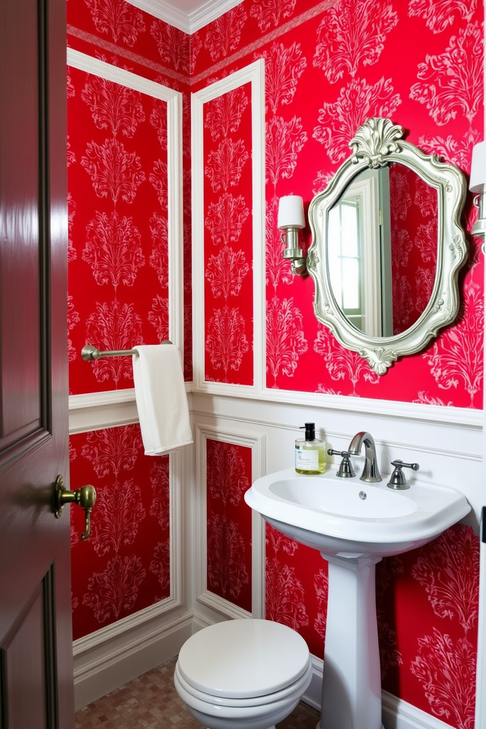 A striking powder room featuring bold red wallpaper adorned with intricate patterns and white trim that adds a touch of elegance. The space is complemented by a chic pedestal sink and a vintage-style mirror that reflects the vibrant color scheme.