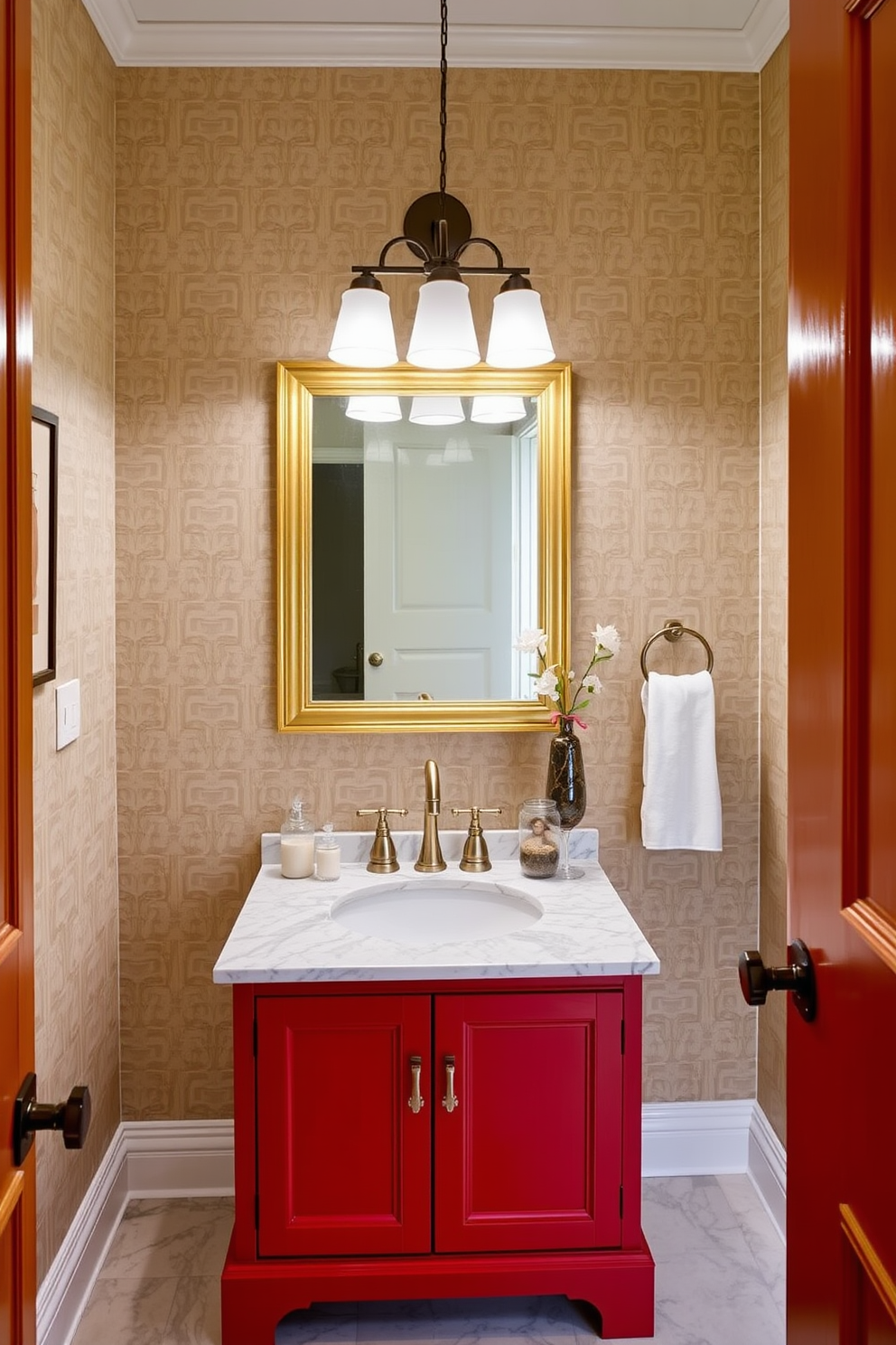 A vibrant red vanity with a polished marble top serves as the centerpiece of this chic powder room. The walls are adorned with elegant wallpaper featuring a subtle pattern, and a modern light fixture hangs above the vanity, illuminating the space beautifully.