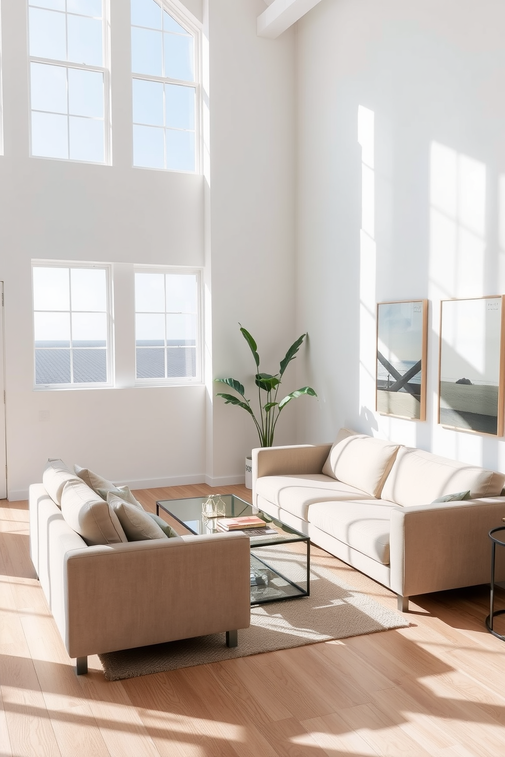 Create an airy feel with minimal decor in a summer loft setting. The space features large windows that allow natural light to flood in, illuminating the light wood floors and white walls. In the living area, a simple beige sofa is paired with a glass coffee table and a single potted plant in the corner. The decor is kept to a minimum, with only a few carefully chosen art pieces that reflect a coastal theme.