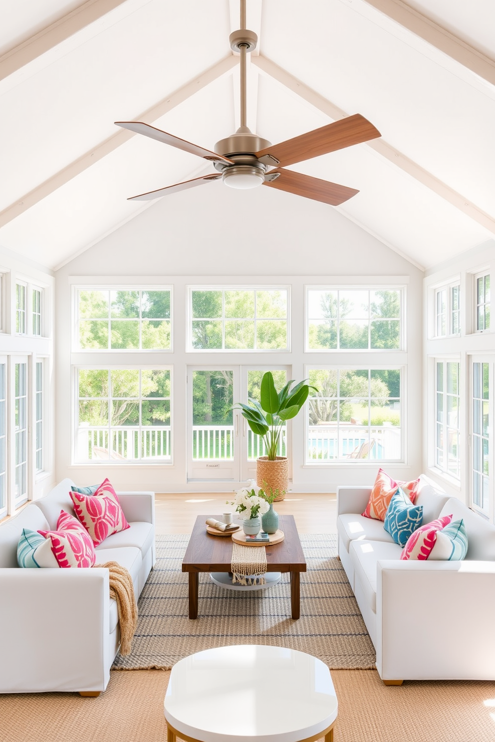 A bright and airy summer loft features an open living space with large windows allowing natural light to flood in. The statement ceiling fan, with its sleek design and wooden blades, adds a touch of elegance while providing a refreshing breeze. The color palette consists of soft whites and light pastels, creating a serene atmosphere. Plush seating is arranged around a central coffee table, adorned with vibrant decorative pillows and a woven throw for added comfort.